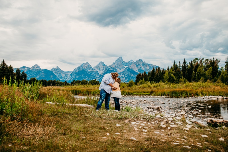 Couples photographer, a young couple kiss near mountain lakes