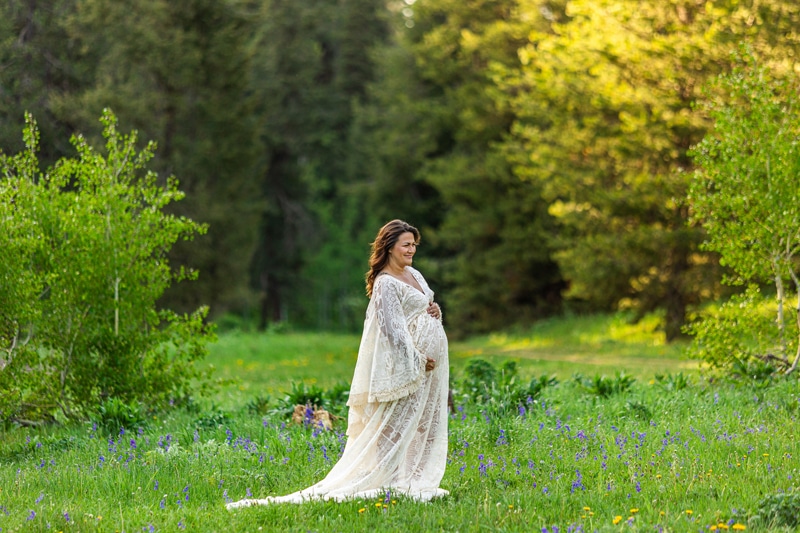 Maternity Photographer, a mother-to-be walks through a grassy meadow.