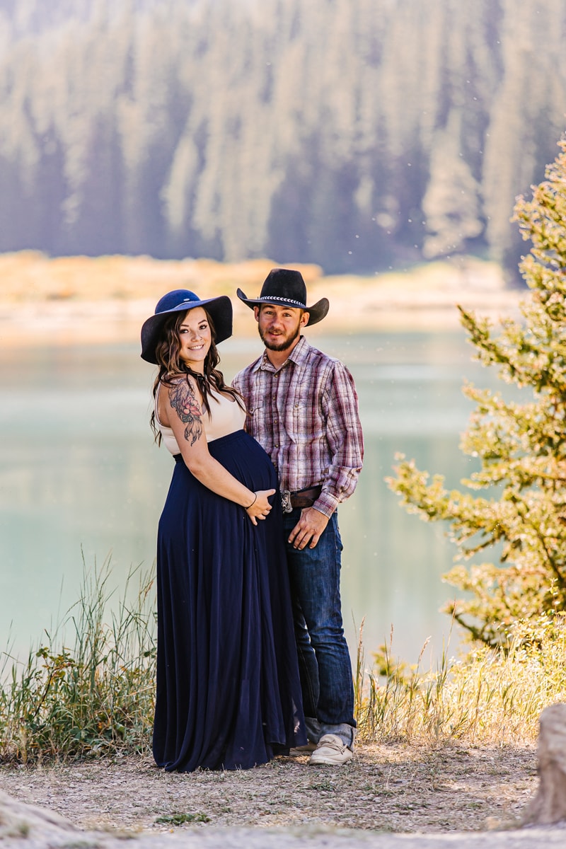 Maternity Photographer, a young mother and father-to-be stand together near the lake