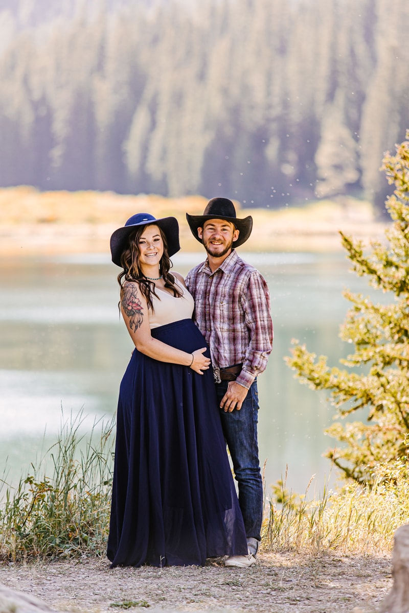 Maternity Photographer, a young mother-to-be and her partner stand together near a lake