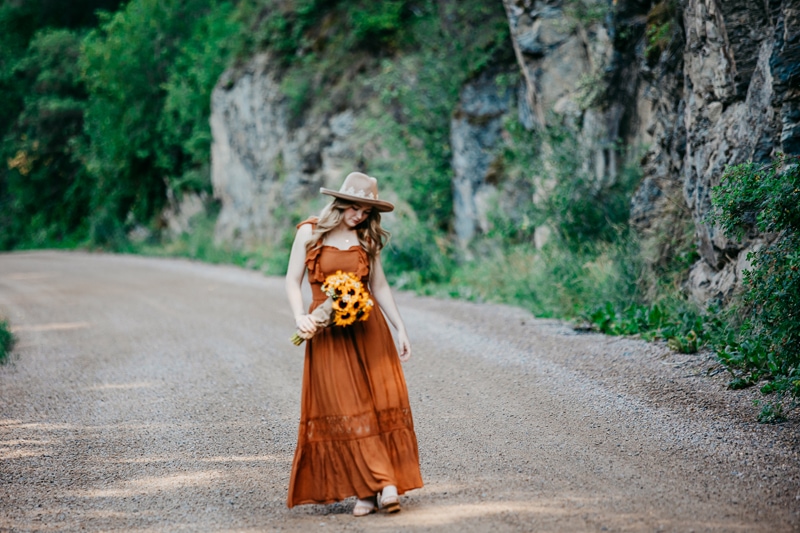 Senior Photographer, High school woman holds sunflowers outdoors