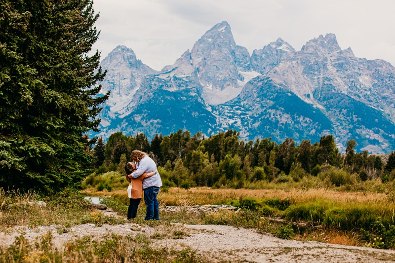 Couples photographer, a young man and woman hug and gaze at each other in the mountains