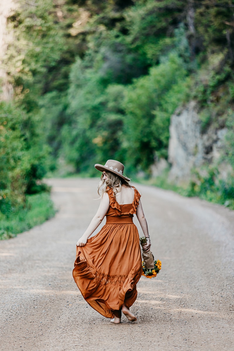 Senior Photographer, a young woman walks down a country road