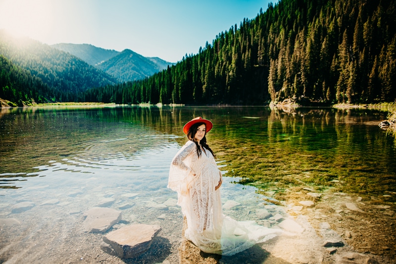 Maternity Photographer, a young mother-to-be stands in shallow lake waters