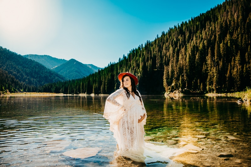 Maternity Photographer, a young expectant mother stands in waters in the forest
