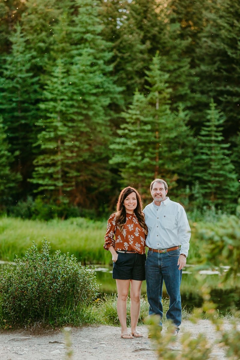 Couples photographer, a husband and wife stand in the forest together smiling