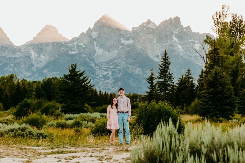 Couples photographer, a young man and woman stand close in mountain meadows