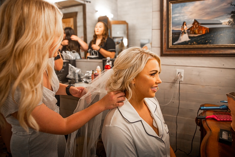Wedding Photography, a bride gets her hair done by a stylist on her wedding day