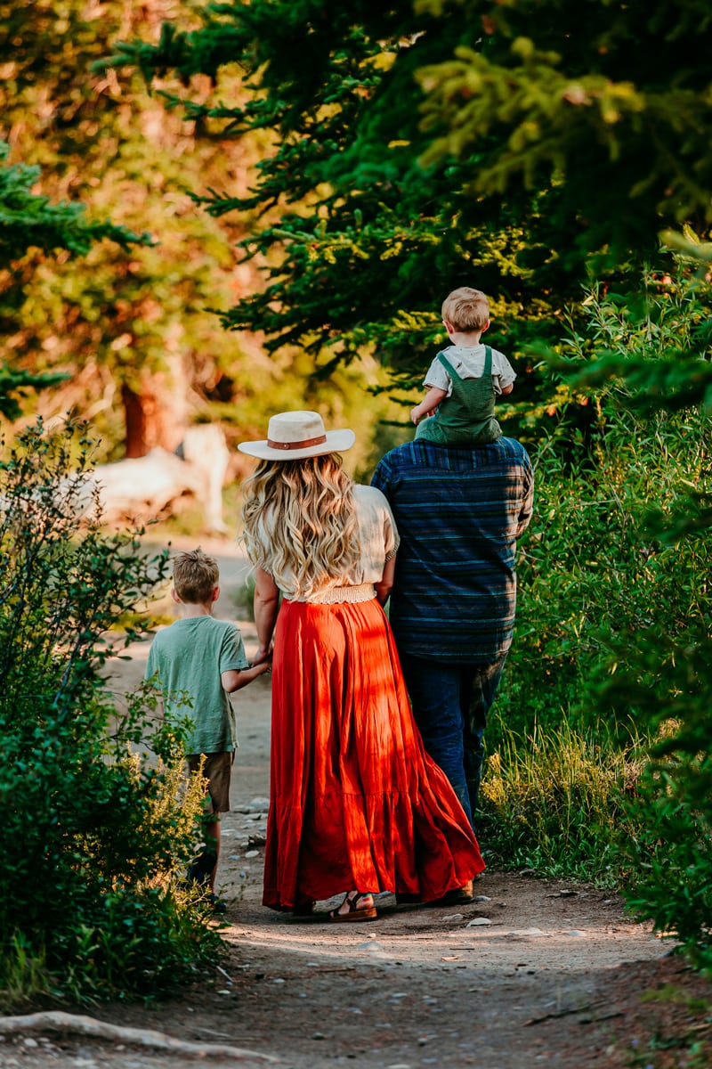 Family Photographer, a young family walks on a forest path