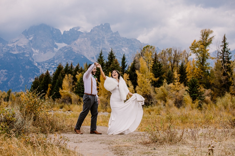 Wedding Photography, a bride and groom dance in the wilderness beneath mountains