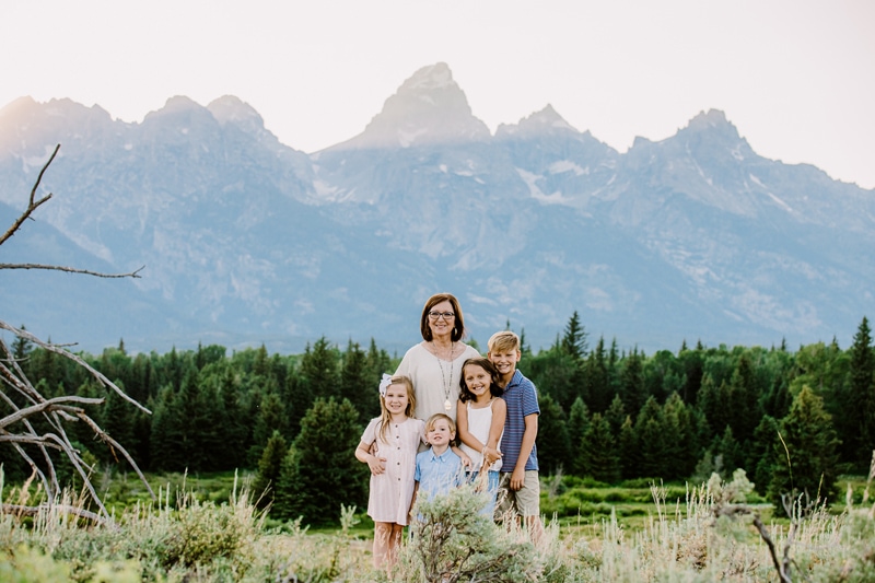 Family Photographer, a grandmother stands with her four grandchildren near the mountains